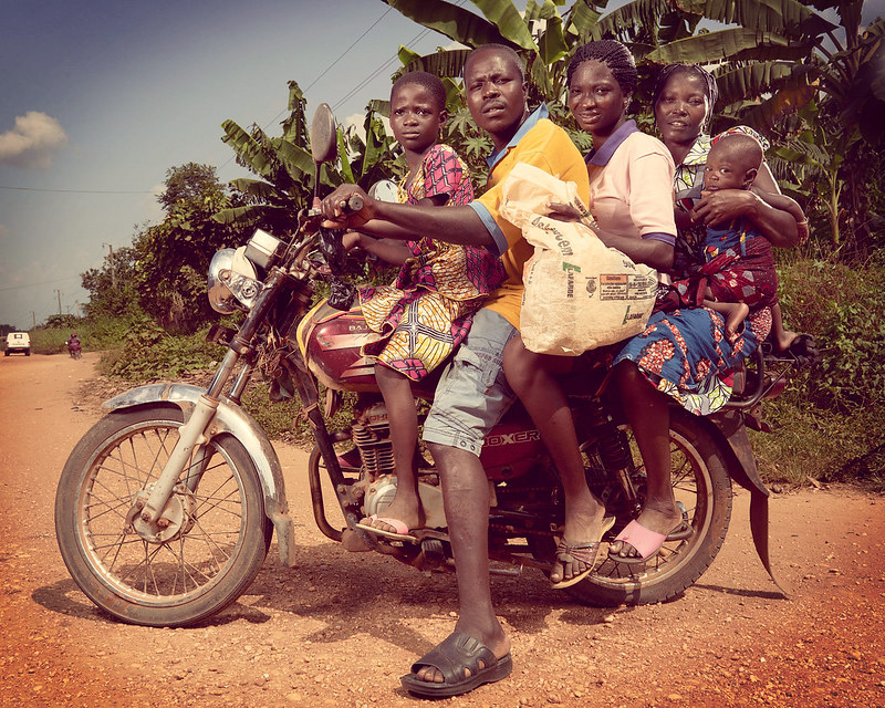 An African family of 5 all sitting on an old motorbike